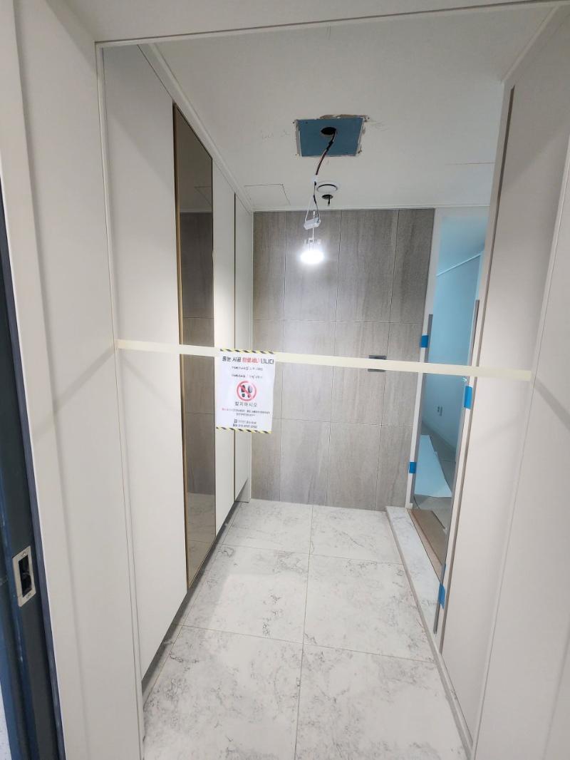벽면 패널과 천장 전등이 보이는 복도 작업 구간