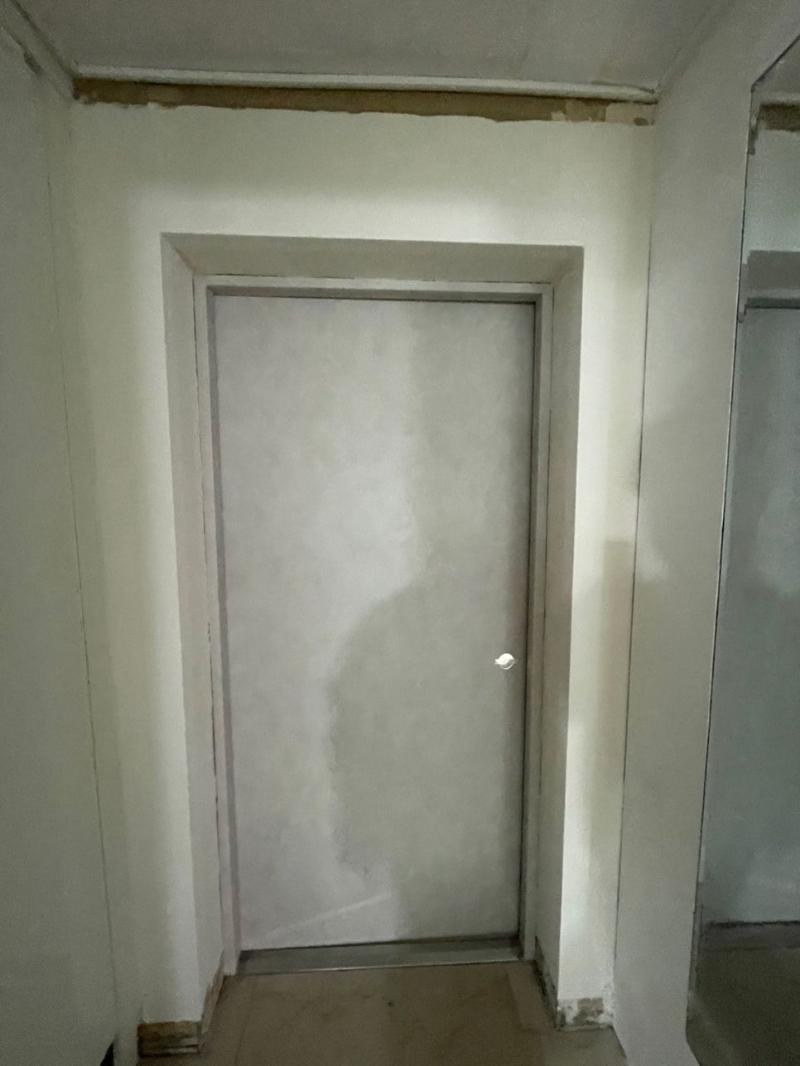 흰색 도어가 설치된 복도 공간의 공사 모습
