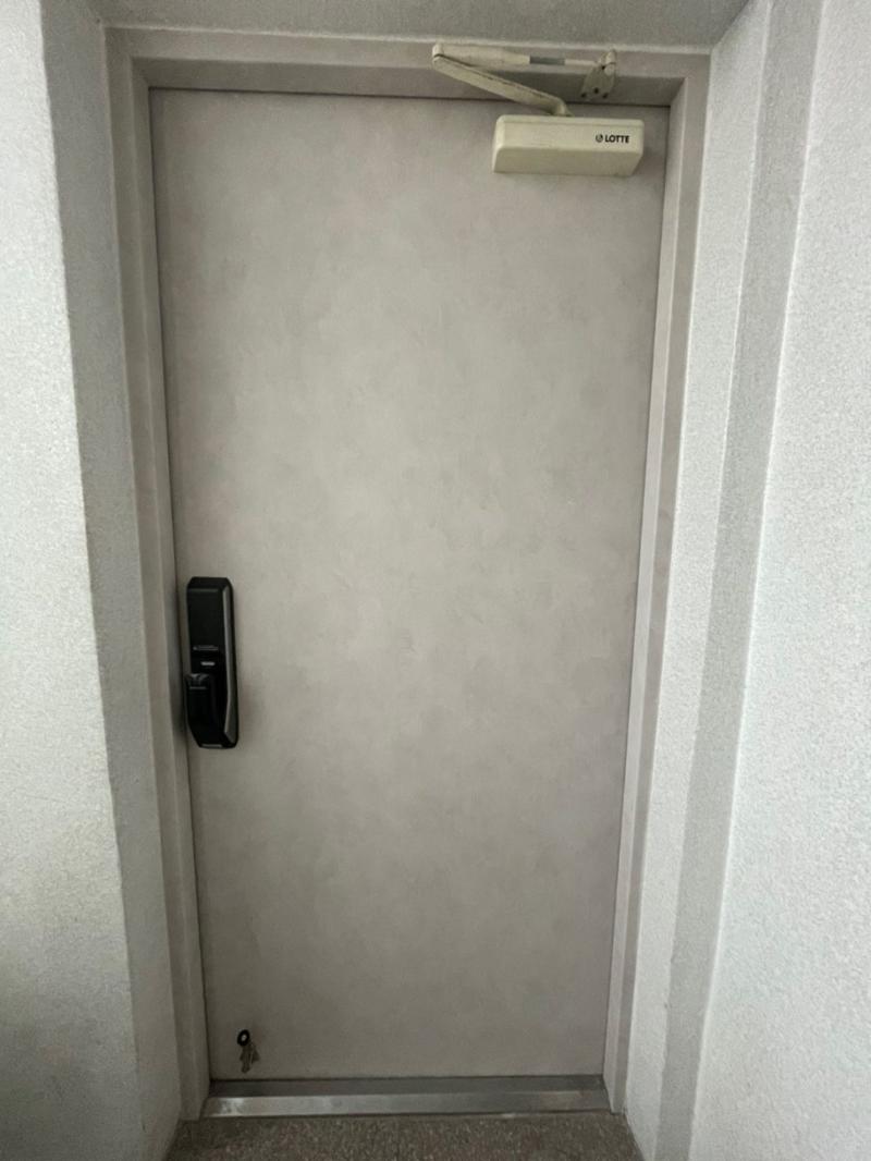 힌지가 노출된 여닫이 도어와 프레임 상부