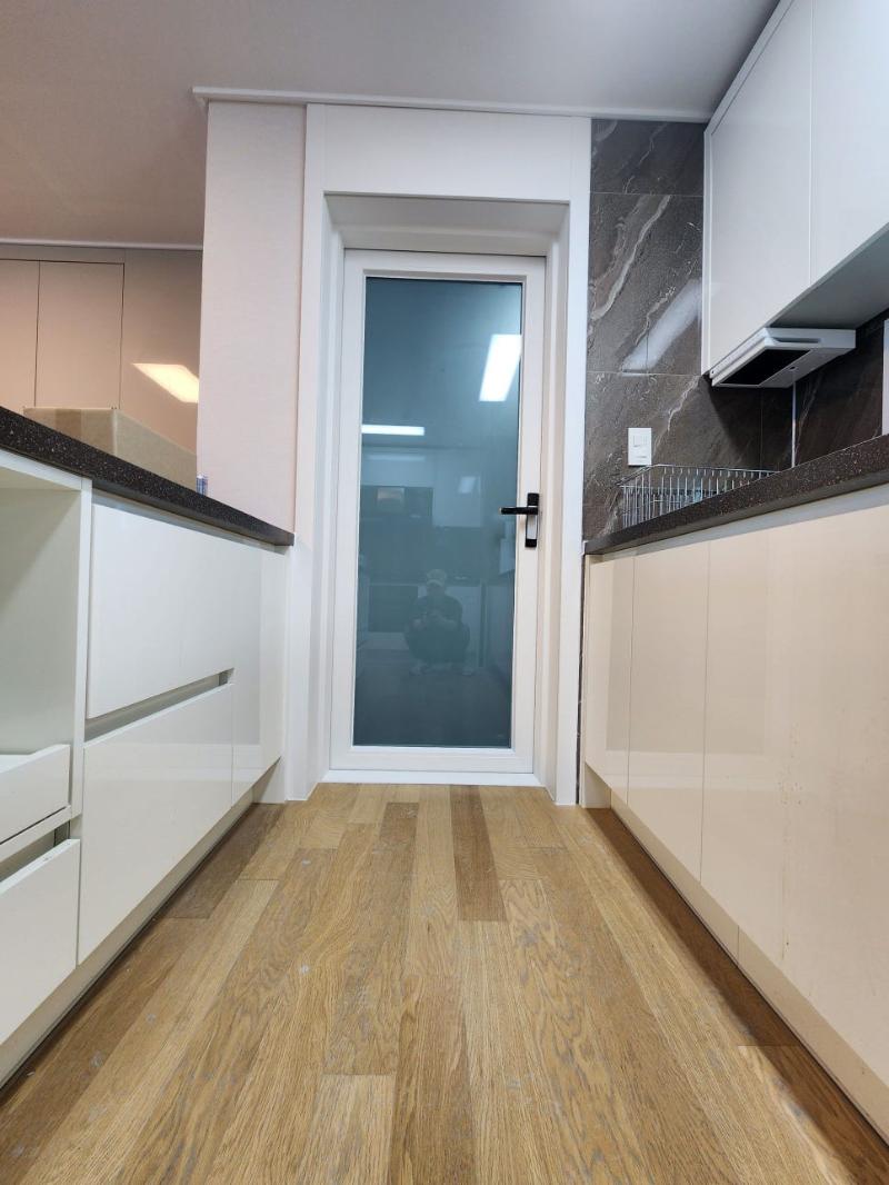 흰색 수납장과 검은색 상판이 배치된 복도