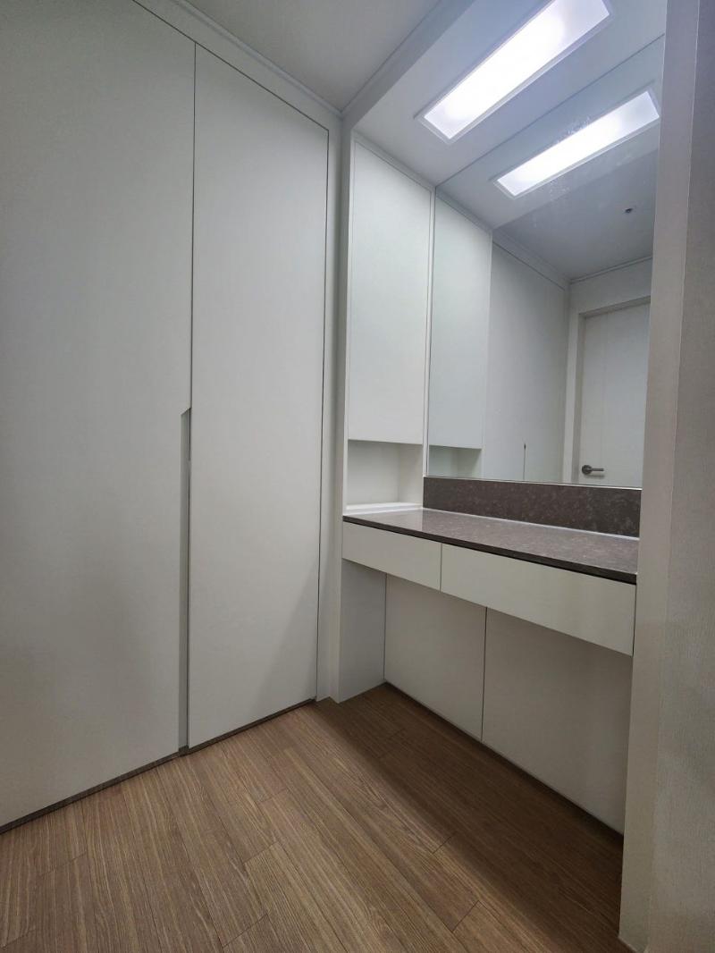 화이트 수납장과 베이지 상판이 설치된 파우더룸