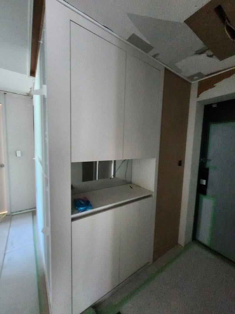 흰색 수납장이 설치된 복도 면 정리 모습