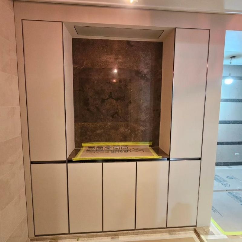 베이직 컬러 수납장과 갈색 벽면 마감재