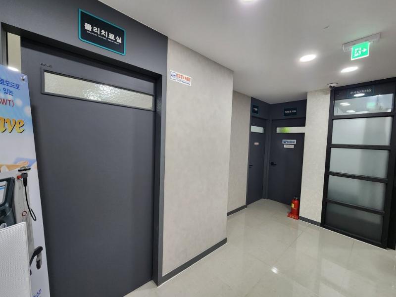 베이지색 벽지와 검은색 도어로 완성된 복도