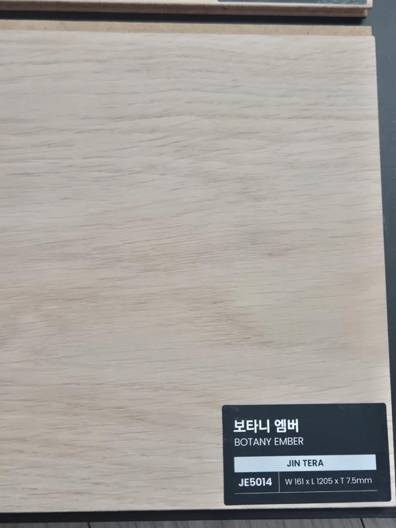 블랙 라벨이 부착된 목재 질감의 자재 디테일