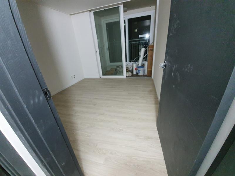 검은색 도어와 목재 패턴 마루가 만나는 지점