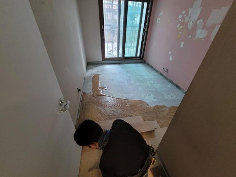 벽면 일부가 벗겨진 상태에서 타일 작업 중인 모습