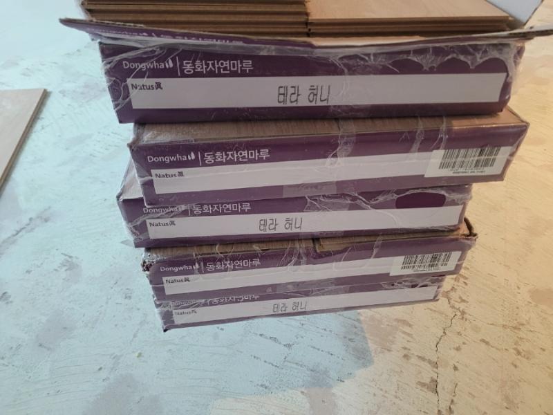 쌓여 있는 동화자연마루 테라 허니 제품 박스