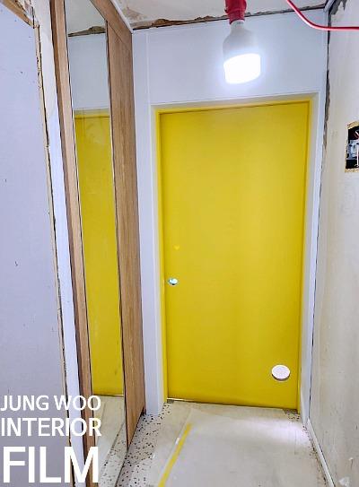 노란색 도어와 거울 프레임이 보이는 복도