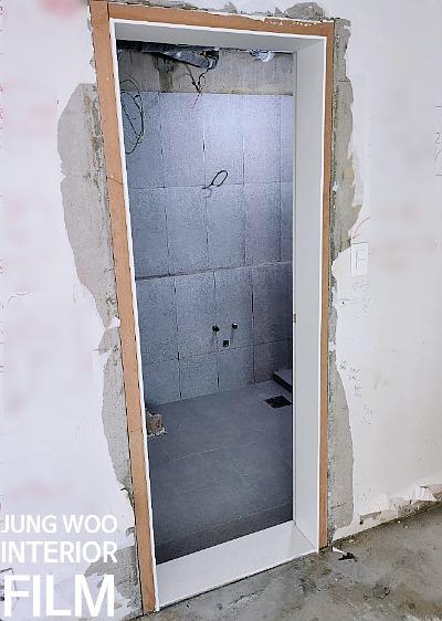 전선이 노출된 천장과 부분적으로 벗겨진 문틀 주변 벽면