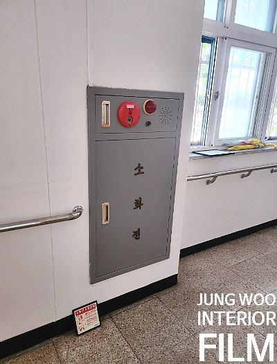 창가 옆에 설치된 금속제 소화기 케이스