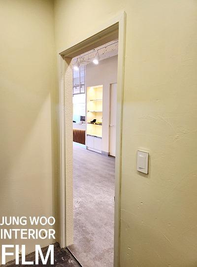 흰색으로 마감된 문틀과 회색 타일 바닥