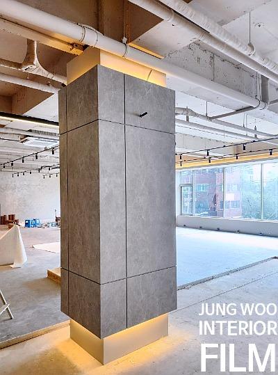 노출 배관과 회색 컬럼이 설치된 콘크리트 바닥 공간