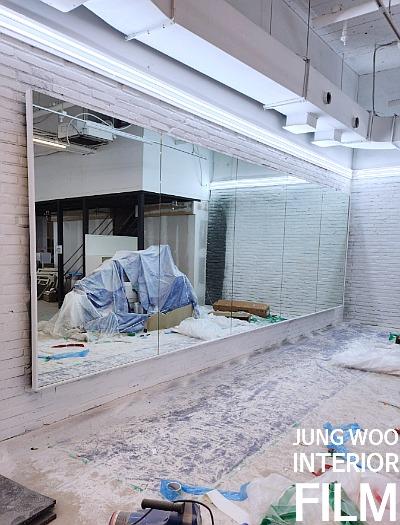 거울 벽과 흰색 벽돌 벽이 있는 공간