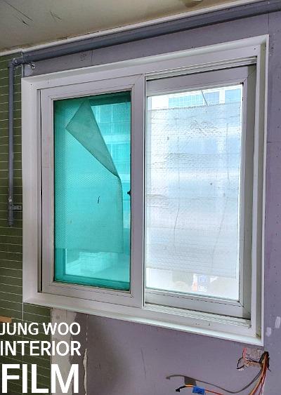 푸른색과 흰색 필름이 부분적으로 부착된 창호