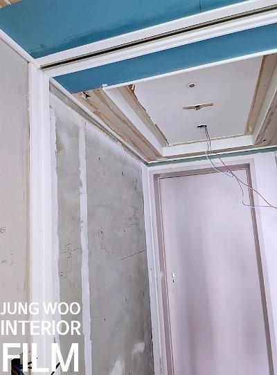 콘크리트 벽면과 파란색 보드가 보이는 천장 하부