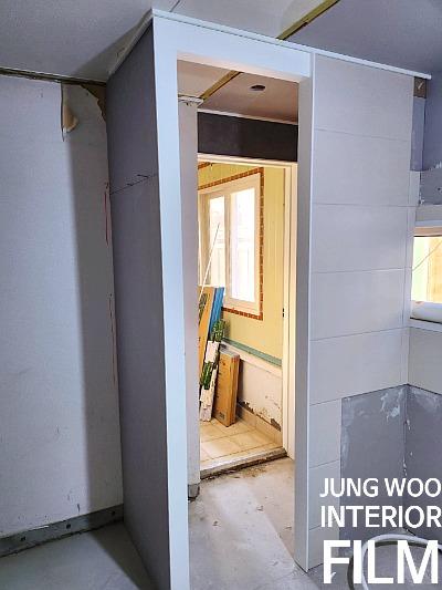 베이지색 벽지와 흰색 타일이 보이는 실내
