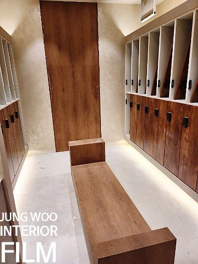 베이지색 마감 벽면과 목재 벤치가 놓인 공간