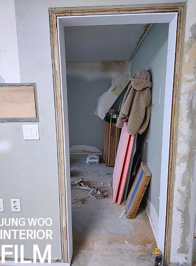 도배 중인 벽면과 공사 잔해물이 있는 복도