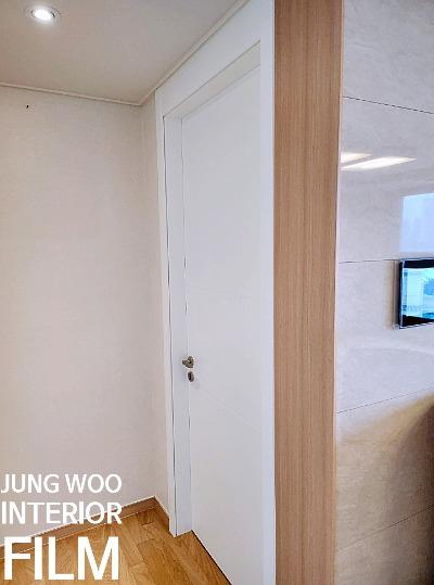 흰 벽과 나무 패널이 어우러진 복도 전경