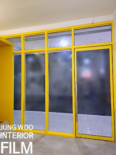 노란색 프레임 도어와 흐릿한 유리 패널 근접샷