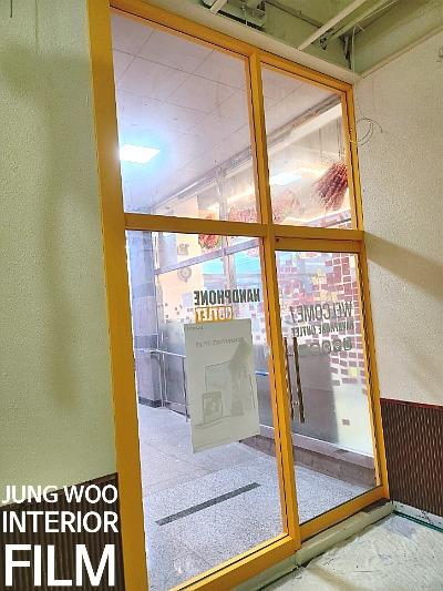황색 프레임과 갈색 패널이 교차하는 실내 공간