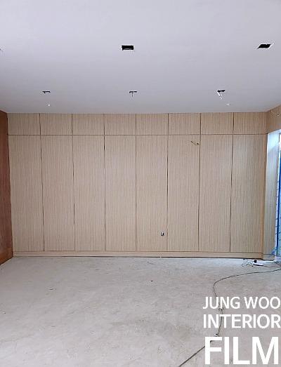 다이렉트 조명 아래 목재 패널 벽면