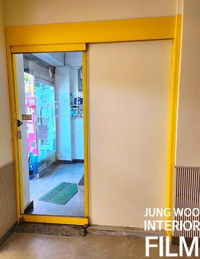 노란색 프레임의 슬라이딩 도어와 외부 풍경