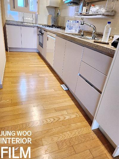 낡은 문틀과 싱크대 하부장을 베이지 톤 필름으로 정돈한 마포구 웰스트림A 사진
