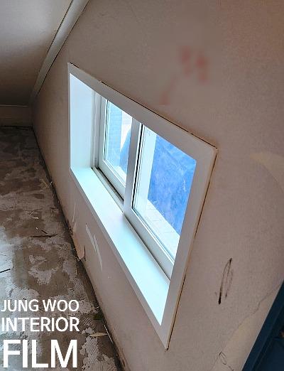 창호가 설치된 흰색 벽면과 먼지가 있는 바닥