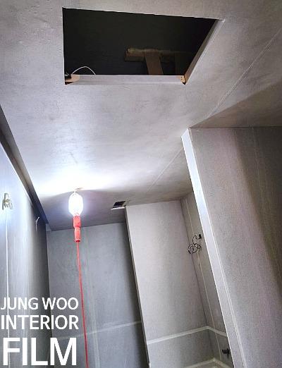 전구가 매달린 천장과 흰색 마감 벽면