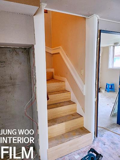 오렌지색 벽면과 목재 계단이 있는 공사 현장