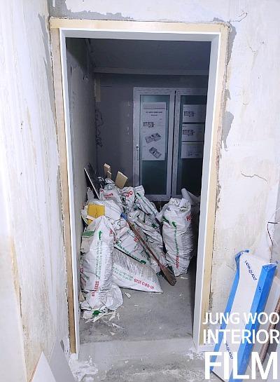 흰색 코팅이 부분적으로 보이는 문틀과 유리 패널 도어