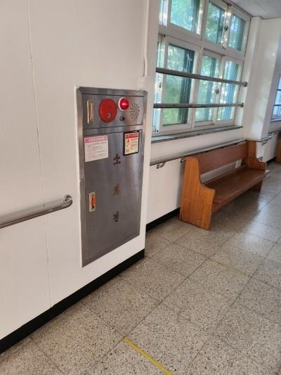 금속제 화재 경보기와 나무 벤치가 놓인 실내