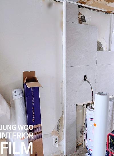 벽면 흠집과 자재 롤이 배치된 작업 구역