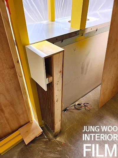 목재 구조물과 노란색 프레임이 맞물린 시공 디테일