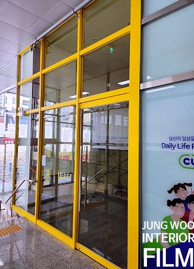 노란색 프레임이 돋보이는 건물 입구와 외부 전경