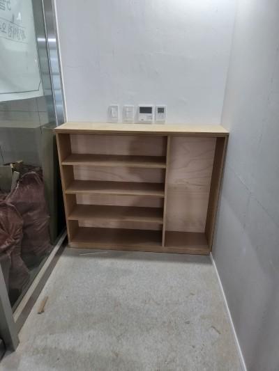 흰색 석재 바닥과 유리문 옆에 설치된 나무 수납장