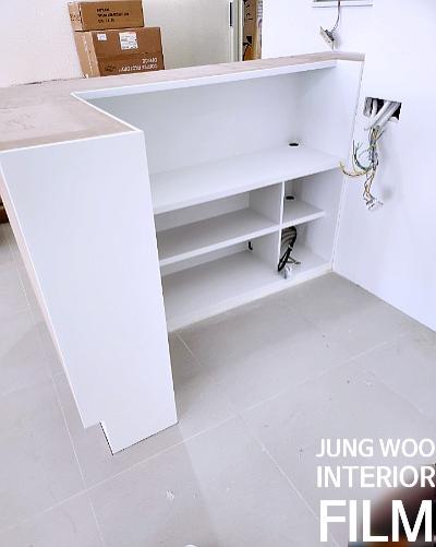 전선이 노출된 상태의 흰색 수납장이 설치된 실내 공간