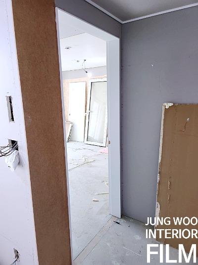 회색 벽과 흰색 문 프레임이 보이는 복도