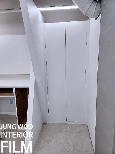 흰색 벽면과 나무 수납장이 배치된 복도 구간