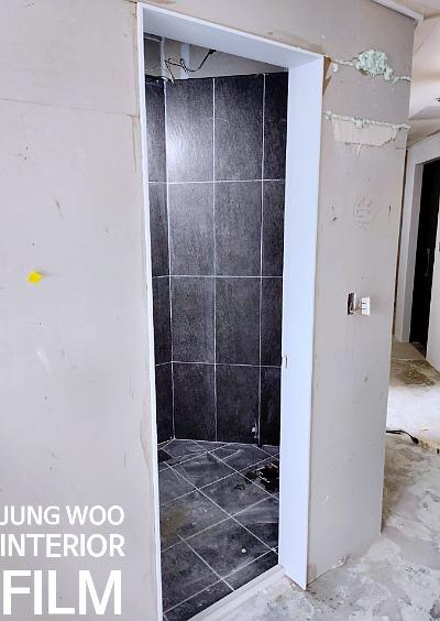 타일 벽과 흰색 벽면이 만나는 복도