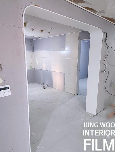 전선이 노출된 천장과 문틀이 설치된 공간