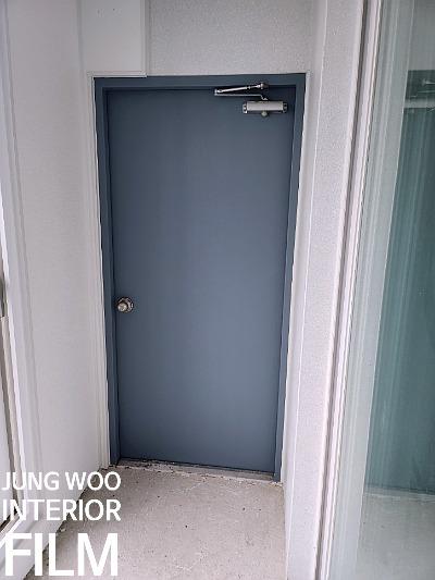 파란색 도어와 금속 브라켓이 보이는 현관