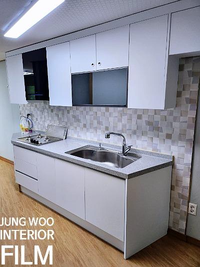 조명 아래 드러난 주방 수납장과 상판의 마감