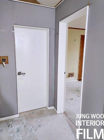 회색 벽면과 흰색 문틀이 마주한 복도