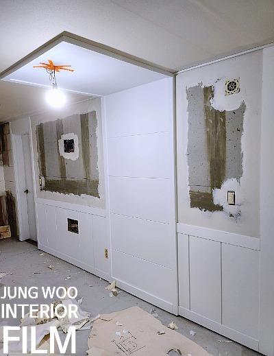 벽면 페인트 작업과 천장 조명이 보이는 복도