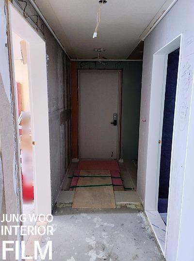 부분 도배가 진행 중인 복도와 문틀