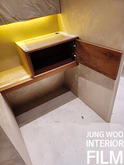 노란색 조명이 설치된 벽면의 나무 수납장