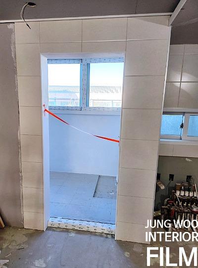 타일 작업 중인 벽면과 문틀 경계